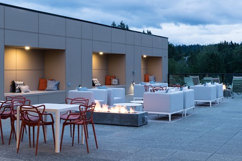 a patio with tables and chairs and a fire pit